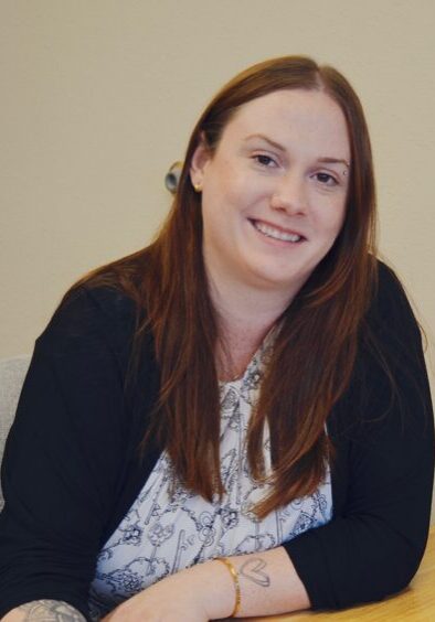 Happy woman smiling in office setting.